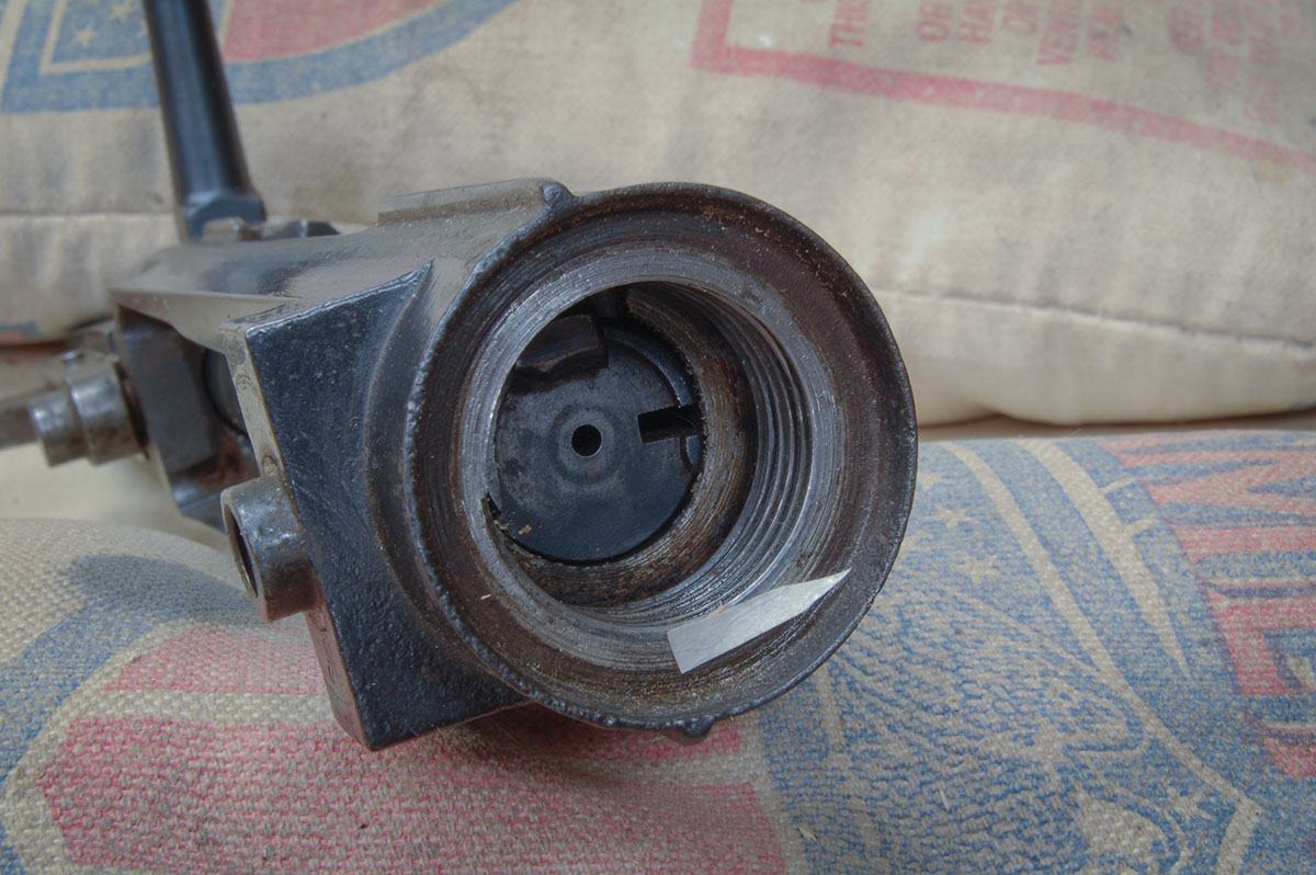 The flange on front of the receiver ring retains handguard. This is filed off before rebarreling.